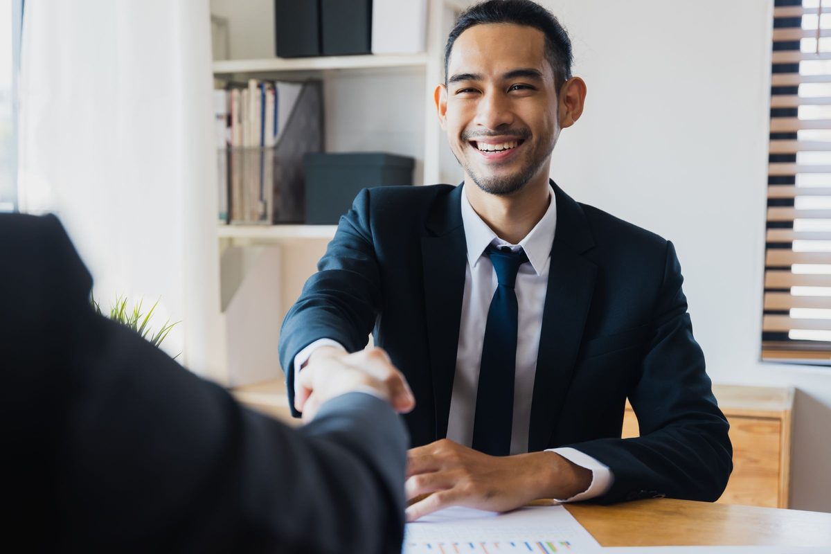 Business owners shaking hands across an office desk