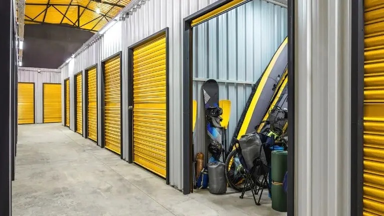Interior corridor of a self-storage facility with yellow roll-up doors